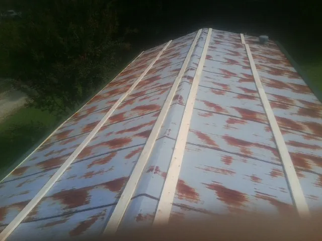 Rusted metal roof panels with new wood purlins before replacement — Storm Damage Roof Repair in Sauk Centre by Roofing Brothers