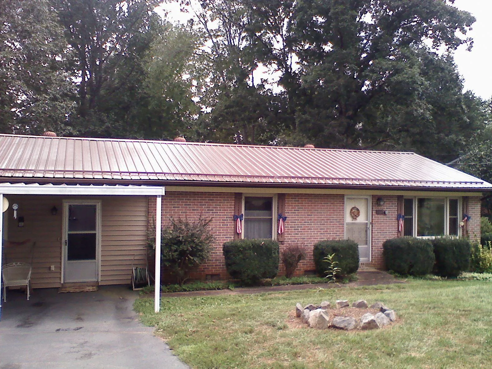 Bronze metal roof and carport on a brick ranch home — Roof Repair work by our crew in Sauk Centre