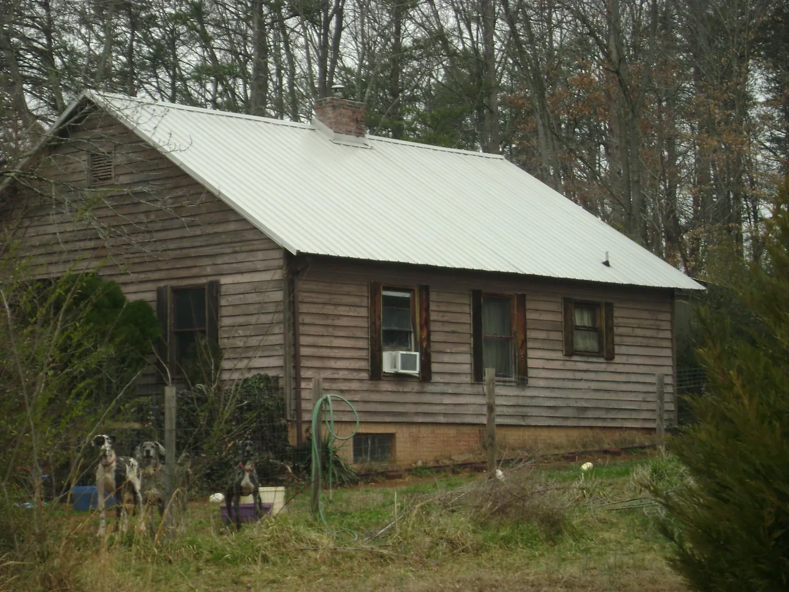 White metal roof on an old wood sided farmhouse, from a Metal Roof Installation job in Sauk Centre